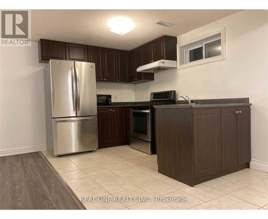 A kitchen with a refrigerator, oven, microwave, and cabinets.