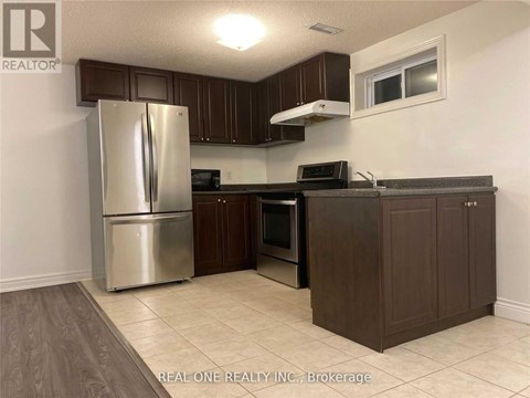 A kitchen with a refrigerator, oven, microwave, and cabinets.