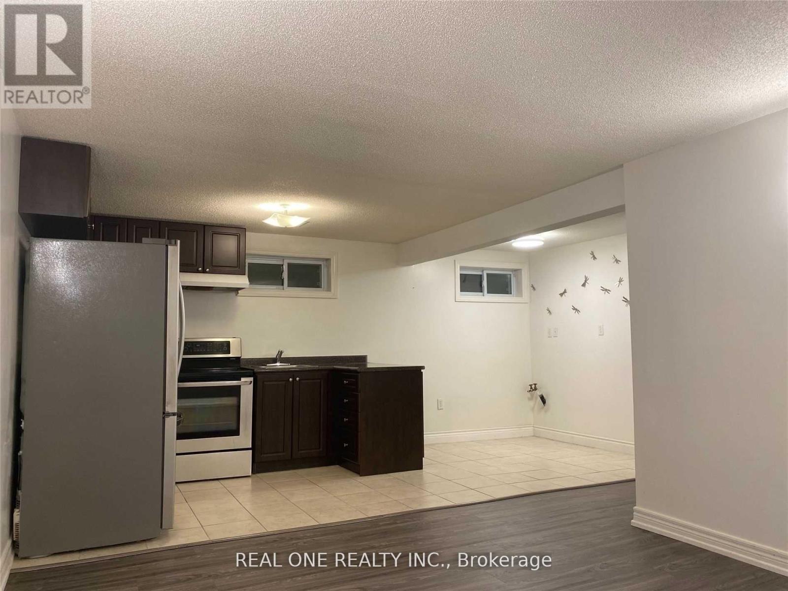A kitchen with a refrigerator, oven, and microwave.