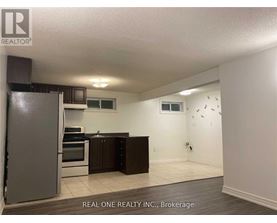 A kitchen with a refrigerator, oven, and microwave.
