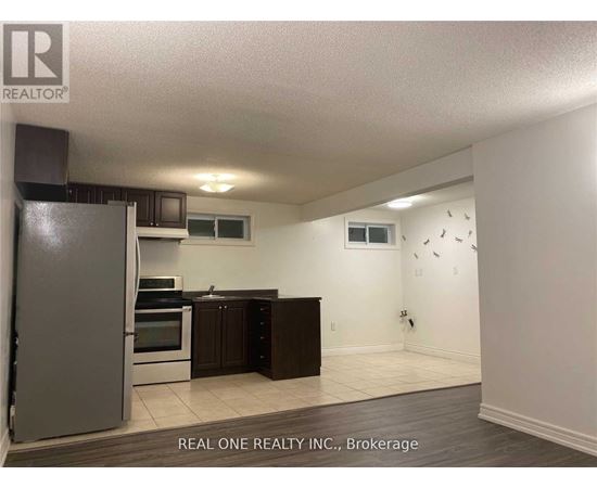 A kitchen with a refrigerator, oven, and microwave.