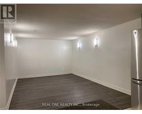 A room with a brokerage sign from REAL ONE REALTY INC.