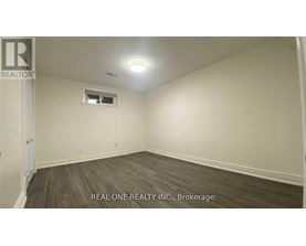 A room with a window and a door, with the text "REAL ONE REALTY INC., Brokerage" on the bottom.