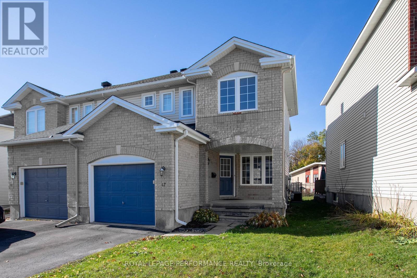 A two-story house with a blue garage door is for sale.