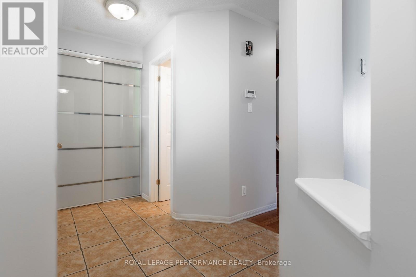 A hallway with a glass door and a bench on the right side.