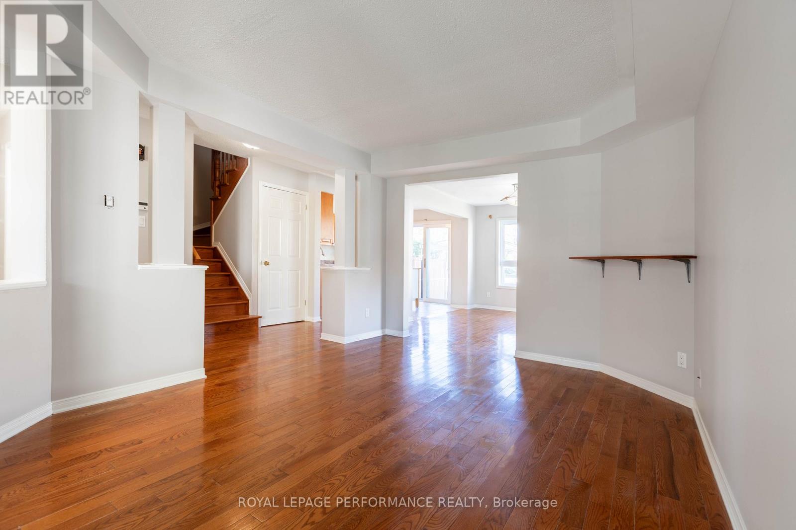 A spacious room with wooden floors and white walls.