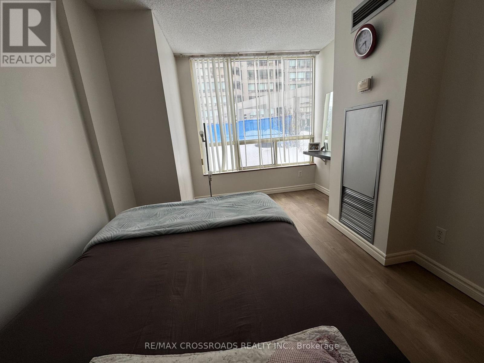 A bedroom with a large bed and a window overlooking a pool.