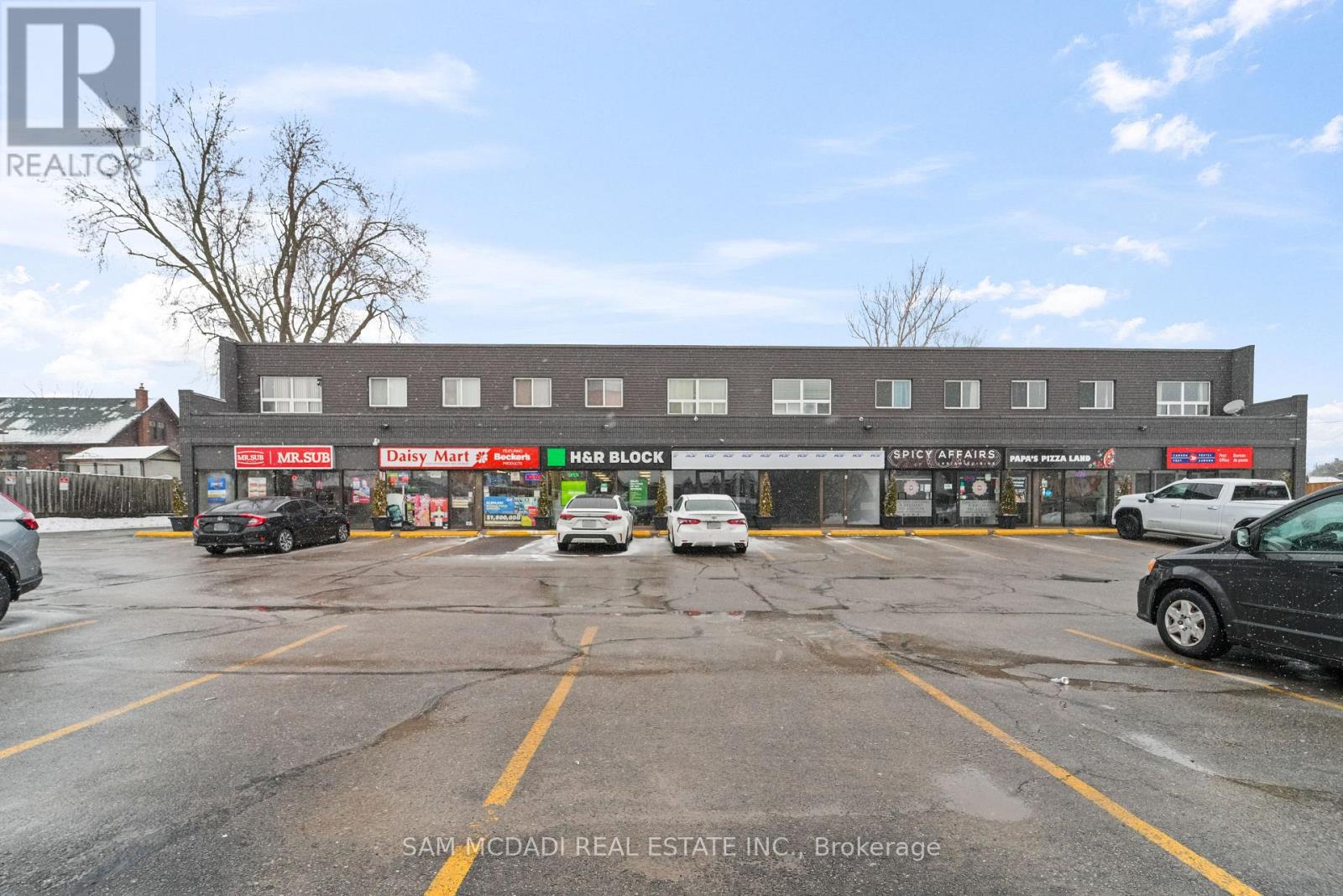 A parking lot with cars and a building in the background.
