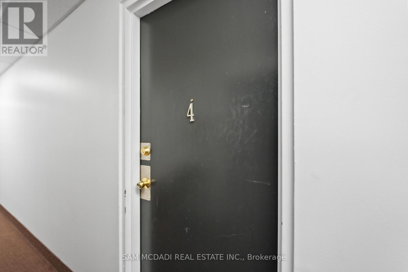 A black door with a gold handle and a number 4 on it.