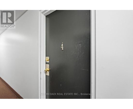 A black door with a gold handle and a number 4 on it.