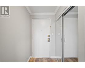 A white door with a gold handle is in a room with white walls.