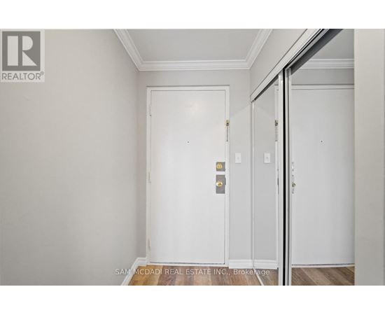 A white door with a gold handle is in a room with white walls.