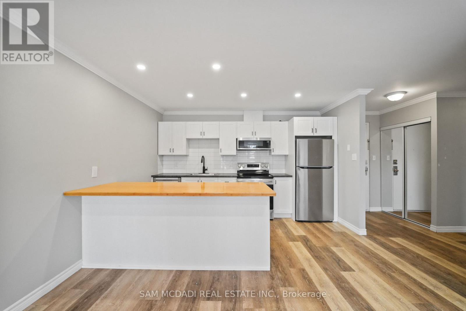 A kitchen with a wooden floor and white walls.