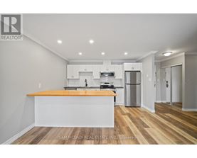 A kitchen with a wooden floor and white walls.