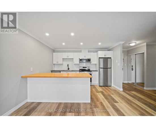 A kitchen with a wooden floor and white walls.