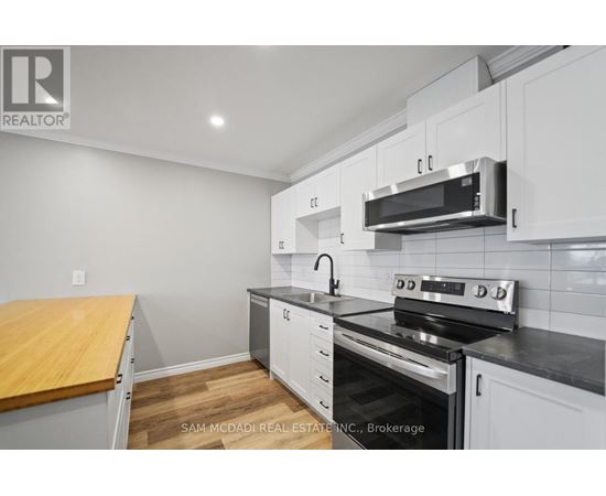 A kitchen with white cabinets and a black stove top oven.