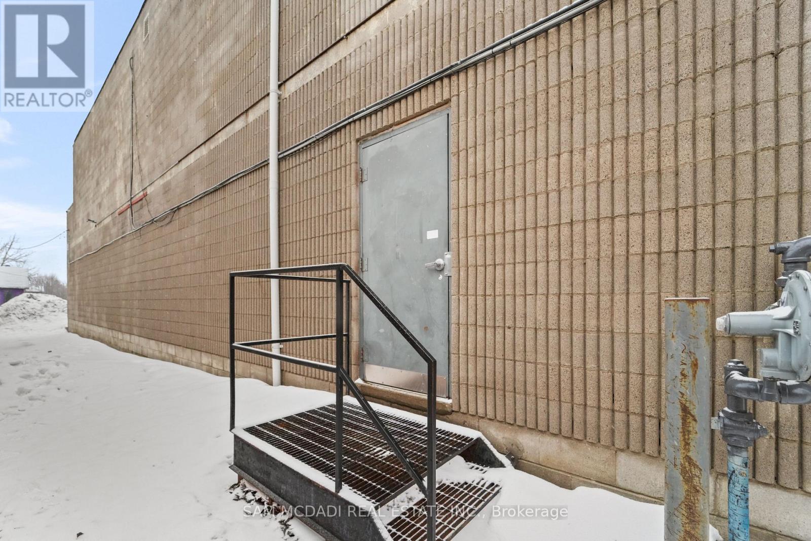 A building with a rusted fire hydrant in front of it.