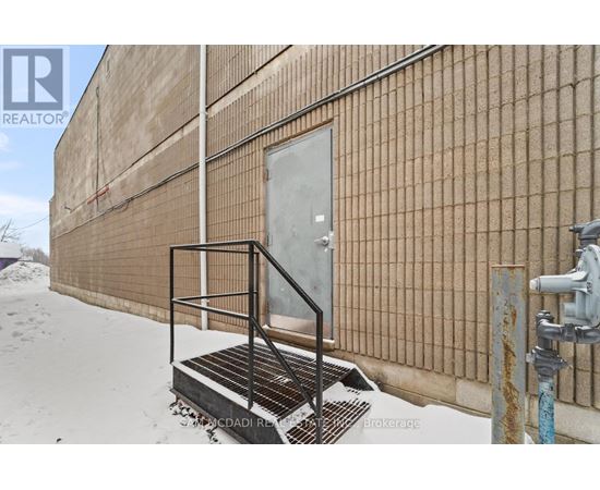 A building with a rusted fire hydrant in front of it.