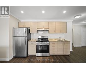 A kitchen with a refrigerator, oven, and cabinets.