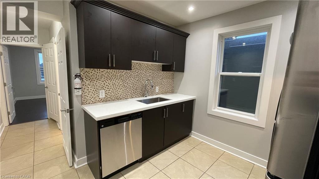 A kitchen with black cabinets and a white countertop.