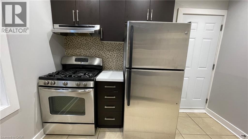 A kitchen with a stainless steel refrigerator and a stove top oven.