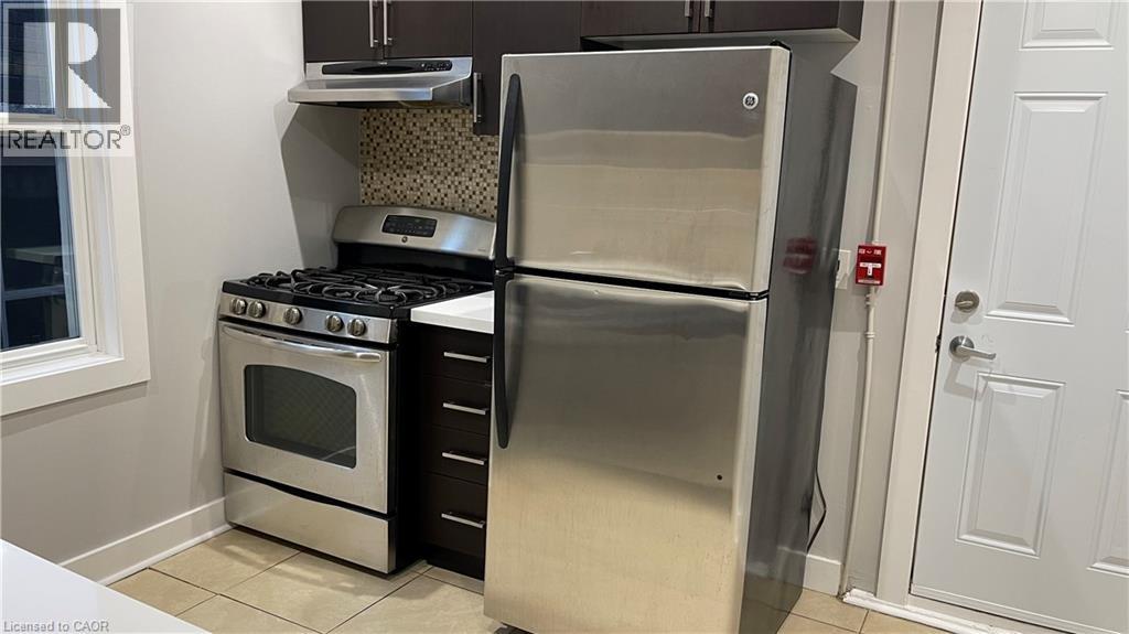 A stainless steel refrigerator and oven in a kitchen.