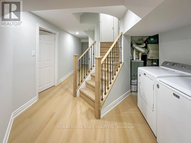 A hallway with a staircase and a washing machine.