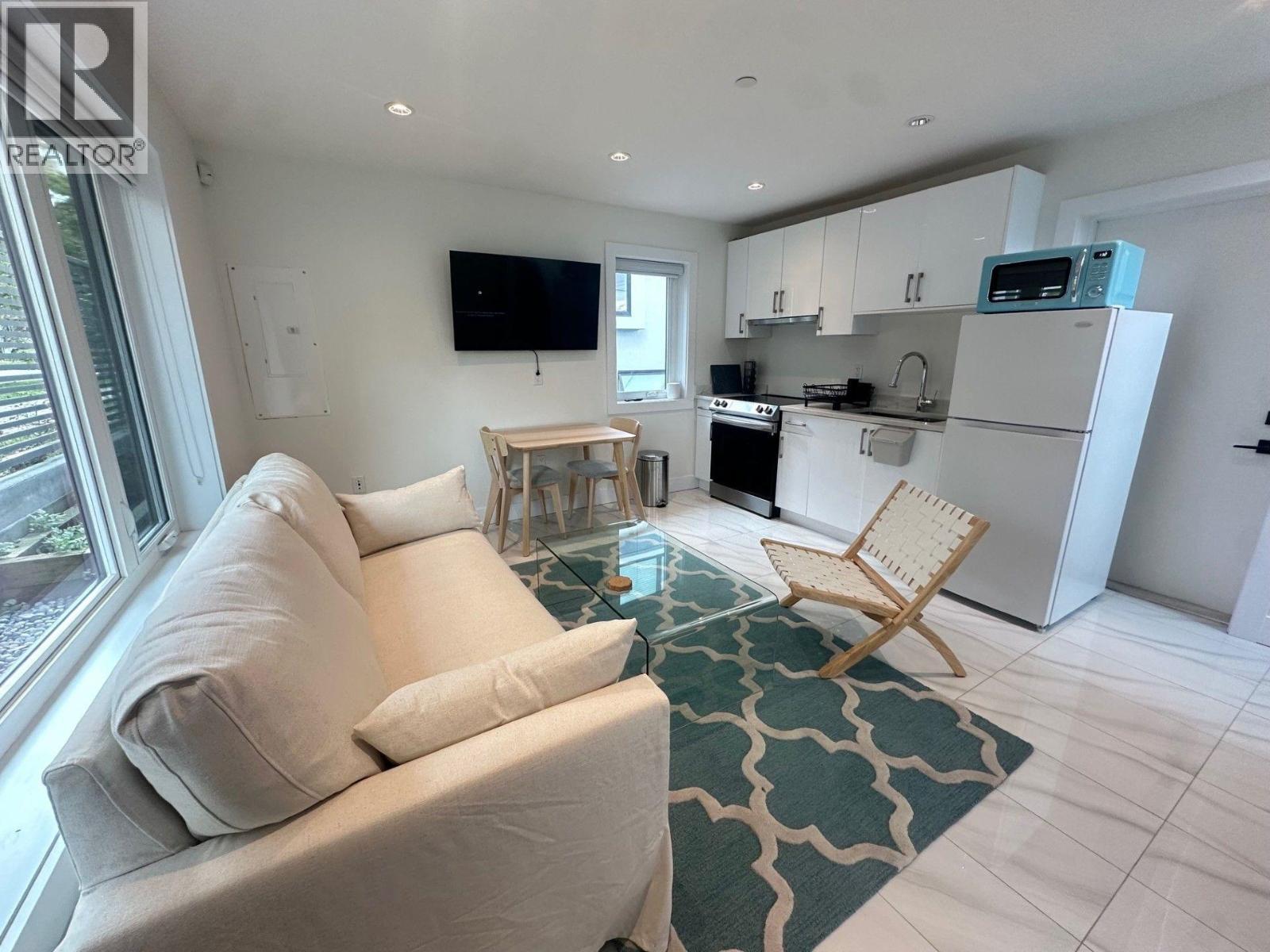 A living room with a couch, chair, and television.