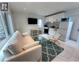 A living room with a couch, chair, and television.