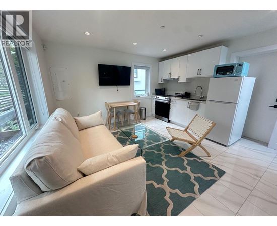 A living room with a couch, chair, and television.