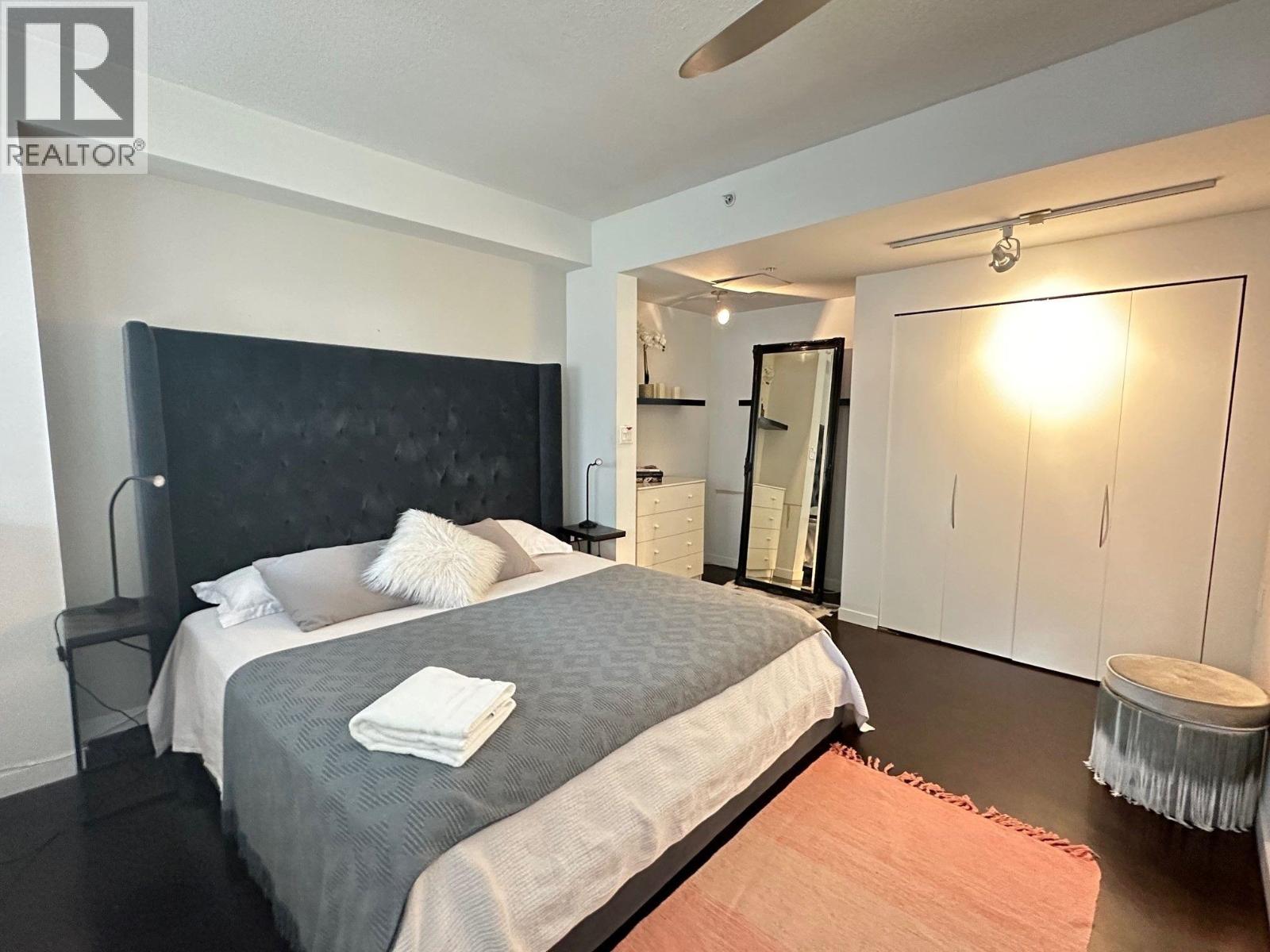 A bedroom with a large bed and a mirror on the wall.