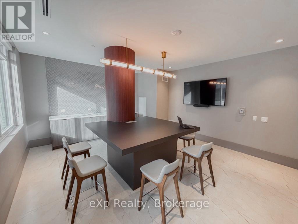 A modern kitchen with a bar stool and a television mounted on the wall.