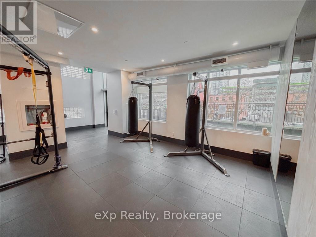 A gym with a punching bag, a pull up bar, and a squat rack.