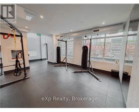 A gym with a punching bag, a pull up bar, and a squat rack.
