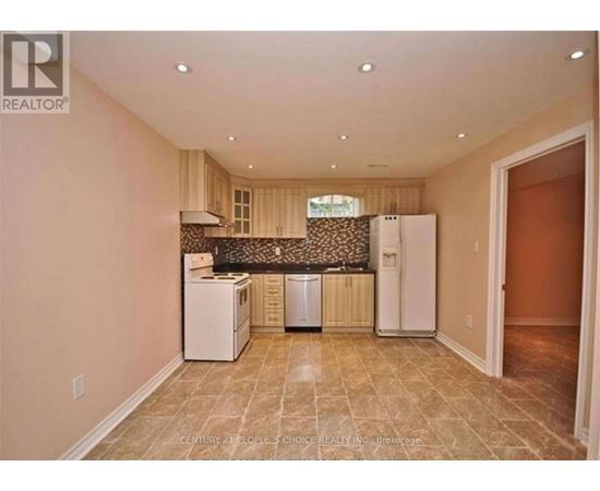 A kitchen area with a dishwasher, a refrigerator, and a washing machine.