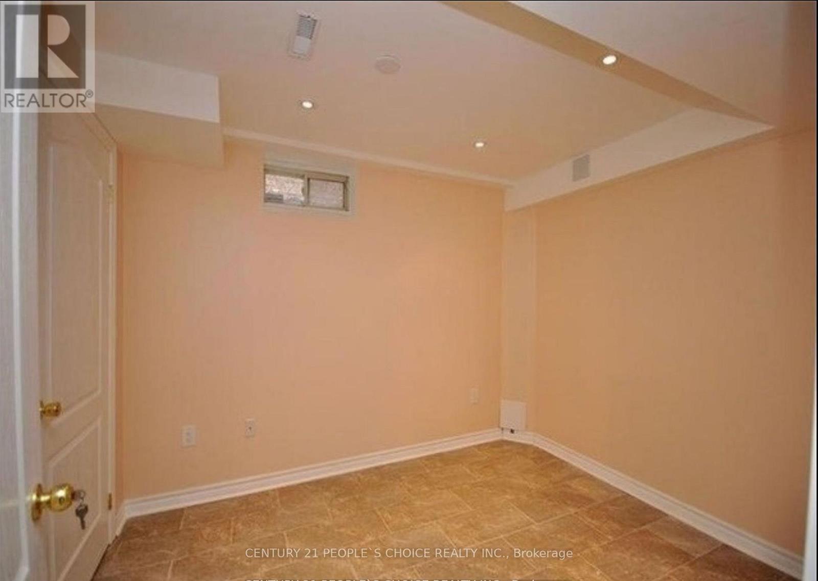 A room with beige walls and a window with a white frame.