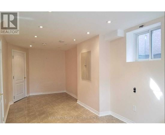 A spacious room with beige walls and a tiled floor.