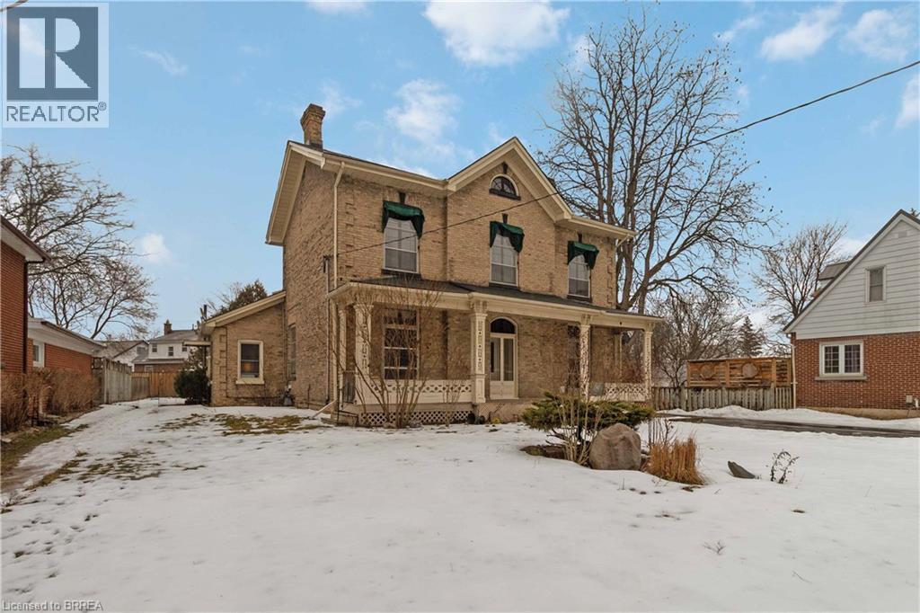 A large, old house with a fence in front of it is for sale.