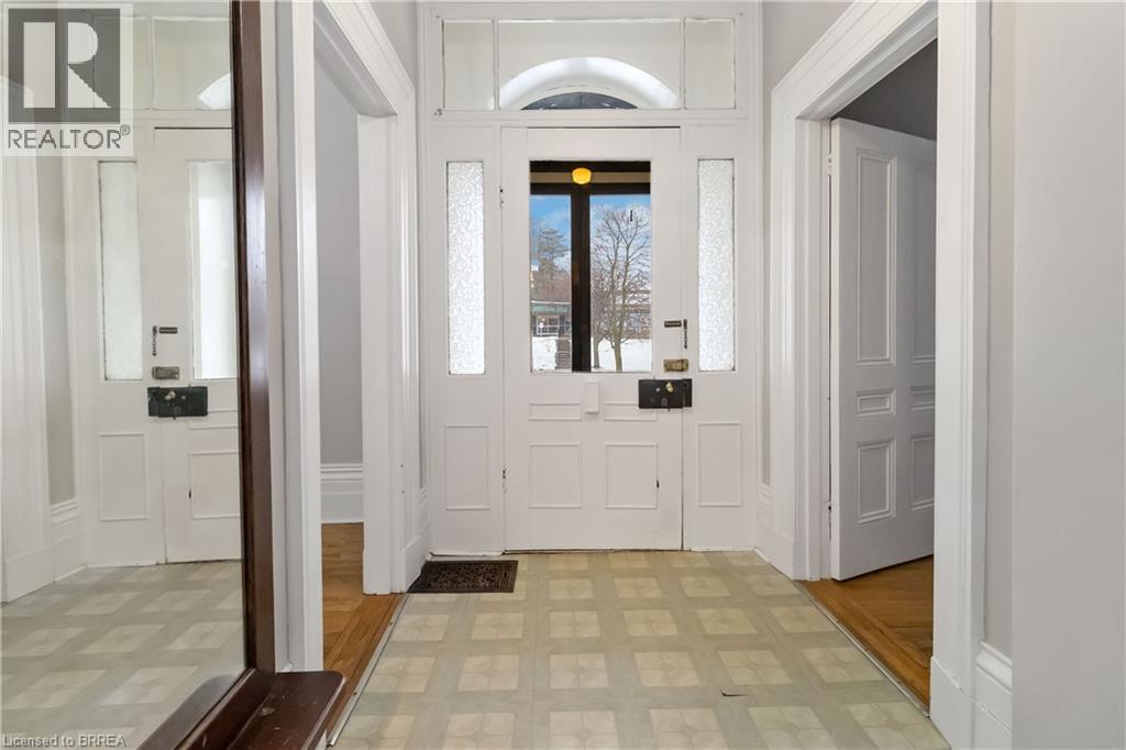 A hallway with a white door and a brown mat on the floor.