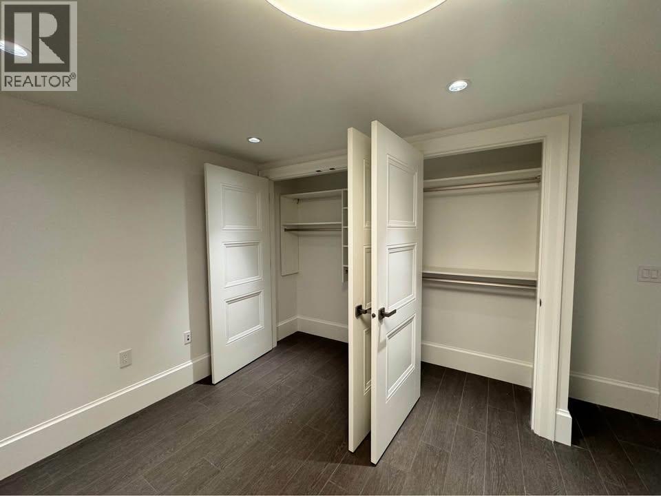 A room with a white door and a grey floor.