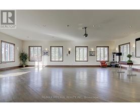A spacious room with wooden floors and large windows.
