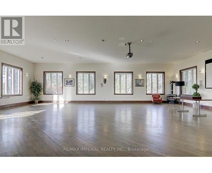 A spacious room with wooden floors and large windows.