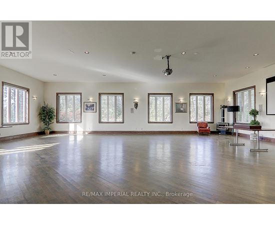 A spacious room with wooden floors and large windows.