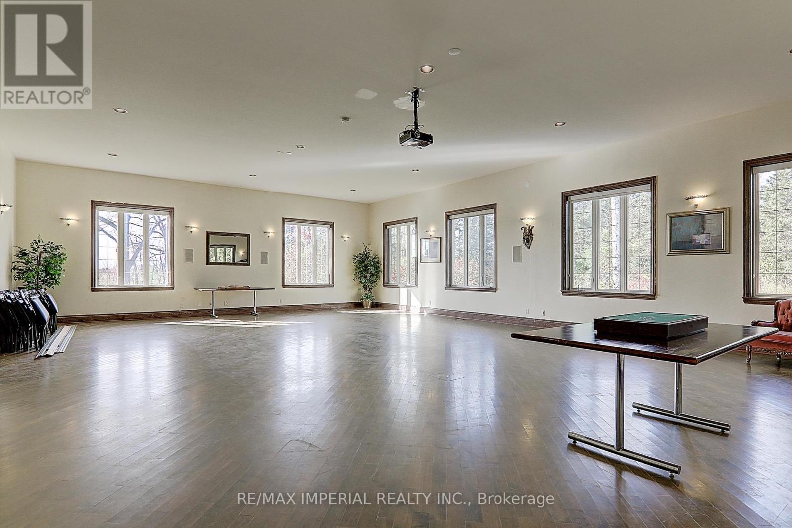 A spacious room with a pool table and a ceiling fan.