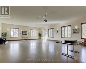 A spacious room with a pool table and a ceiling fan.