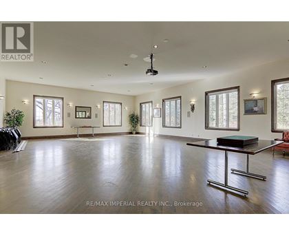 A spacious room with a pool table and a ceiling fan.