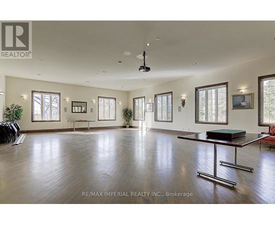 A spacious room with a pool table and a ceiling fan.