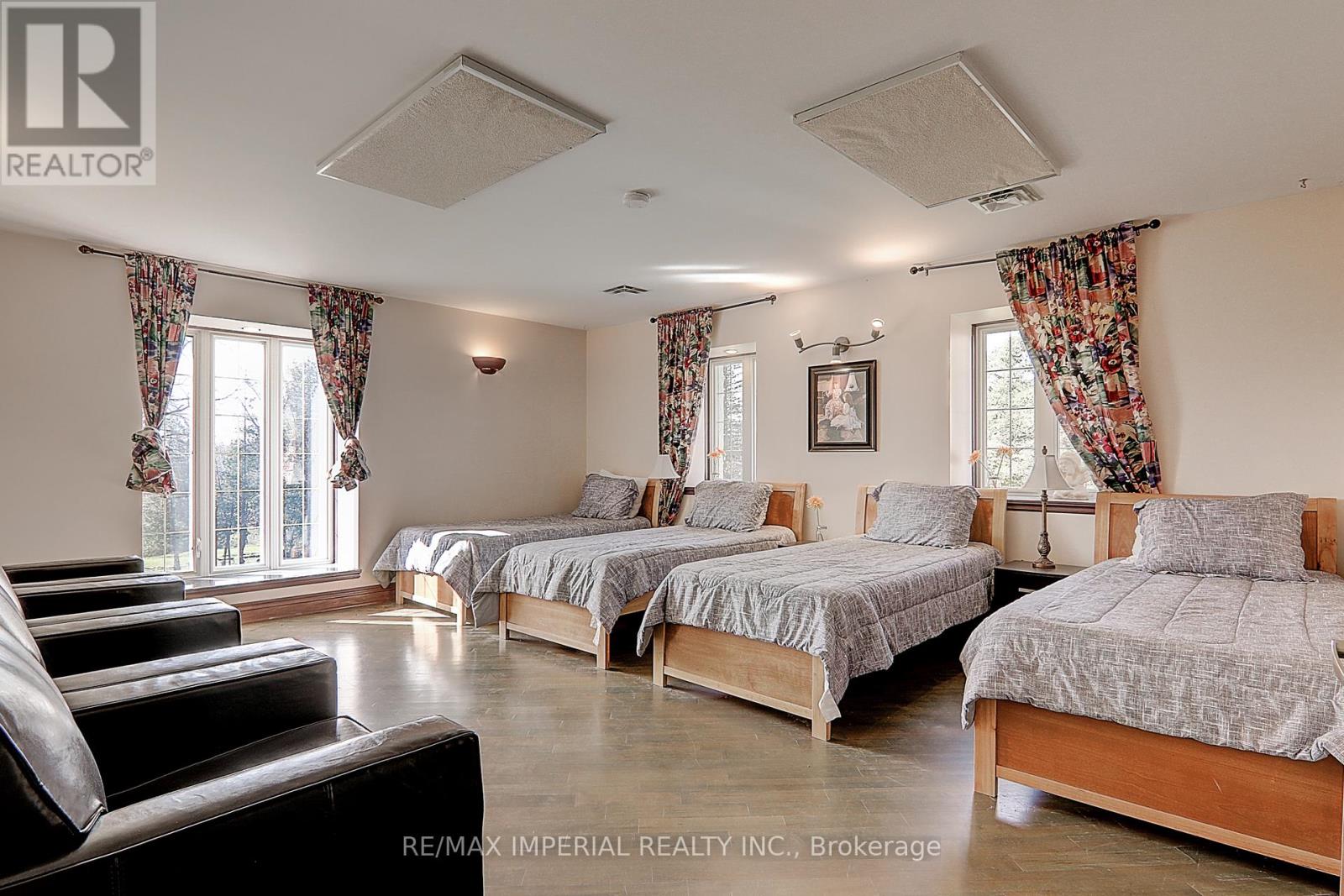 A bedroom with two beds and a couch.