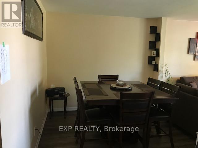 A dining room with a table set for two and chairs around it.