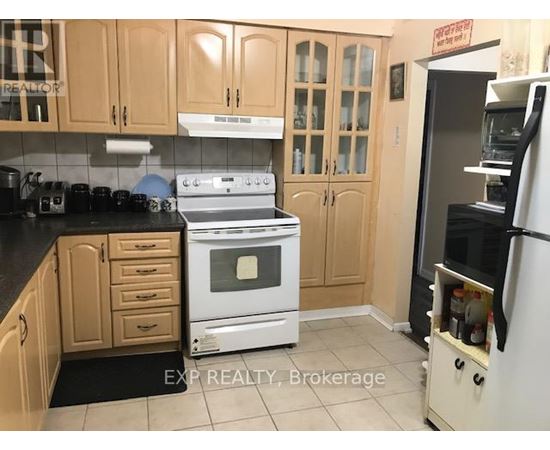 A kitchen with a white stove and wooden cabinets.